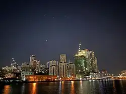 Buildings along the Pasig River at night with the Binondo-Intramuros bridge at far right