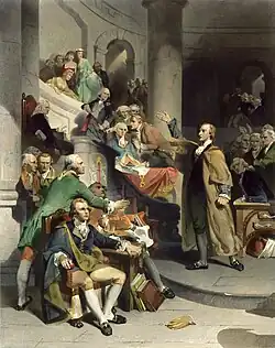 Upper-class middle-aged man dressed in a bright red cloak speaks before an assembly of other angry men. The subject's right hand is raise high in gesture toward the balcony.