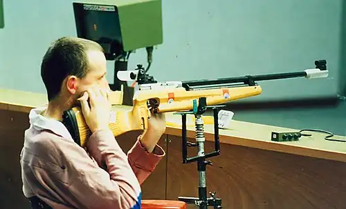 Front sight extensions on an ISSF air rifle are effectively muzzle shrouds used to increase the sight radius, aiding in precise aiming with iron sights.