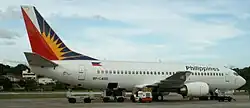 White commercial jet with red, blue and yellow tail