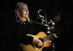 A woman plays guitar.