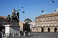 Piazza del Plebiscito, monument to Charles VII of Naples (later Charles III of Spain) in foreground and the cupola of the Galleria Umberto I in background. Naples, Italy.