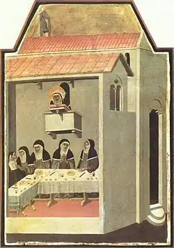 Five nuns eating in a dining hall with a senior nun watching over them from above