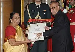 Woman is given award by man