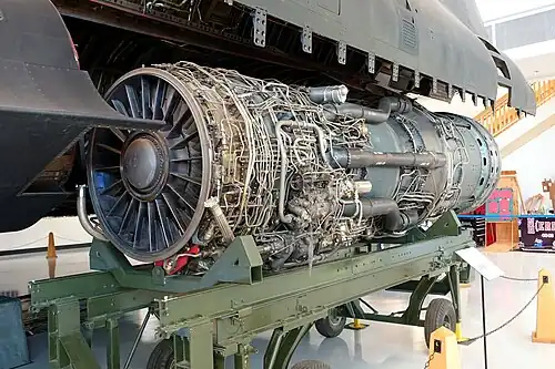 View of J58 engine shows some features required for flight at Mach 3.2: titanium inlet guide vanes and first stage compressor blades for lighter weight at high ram temperatures, transonic first stage compressor blades and low hub/tip ratio compressor entry, both scaled from the bigger Mach-3 J91 engine compressor, 2-position flaps on the inlet guide vanes and three of the six bypass tubes.