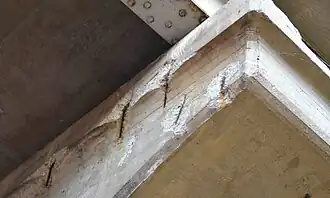 Rusting rebar has expanded and spalled concrete off the surface of this reinforced concrete support.