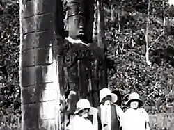 Visitors next to a Maya estela