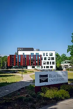 The main building of Riga Stradiņš University with the campus sign in the foreground