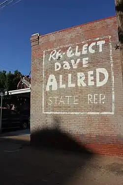 An advertisement on the side of a building that reads: "Re-elect Dave Allred, State Rep."
