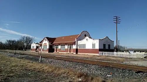 A building which is 195 feet (59&nbsp;m) long and 26 feet (7.9&nbsp;m) wide. The building architecture is eclectic, exhibiting both Spanish and Italian influences. The lower section of the exterior wall is brick, while there is covered with stucco. The stucco is painted white, decorated with tan painted trim. The center section has a gabled roof, with semicircular walls extending above the roof line on each end. The large window in the center is arched. Other windows have an arch design embedded in the stucco.