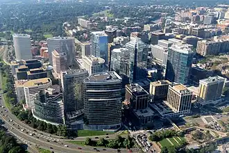 An aerial view of several tall glassy office buildings.