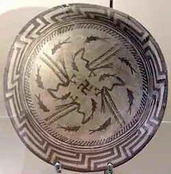 Samarra plate, with an abstract rim, a circle of eight fish, and four birds catching four fish that swim towards a central swastika; circa 4000 BC; painted ceramic; diameter: 27.7&nbsp;cm; Vorderasiatisches Museum Berlin