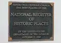 A National Register of Historic Places marker on the wall at the front of the church.