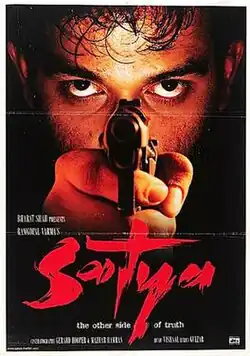 The poster features face of a man behind the revolver he is pointing at the viewer. The film title appears at bottom.