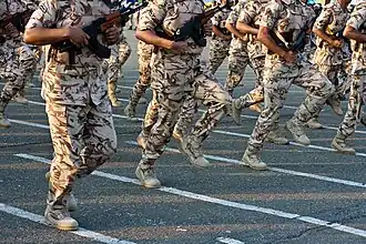Saudi Arabia National Guardsmen run past in three-colour desert DPM.