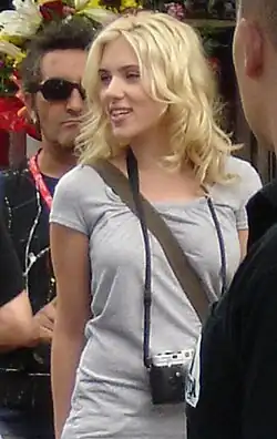 Scarlett Johansson with tousled medium length blonde hair loosely around her shoulders and face, looking to her right.