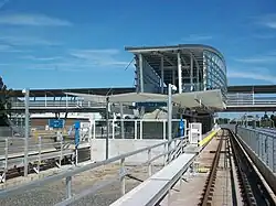 Approaching Sea Island Centre station from the west. Access to the station is via an elevated walkway above the tracks and adjacent roads.