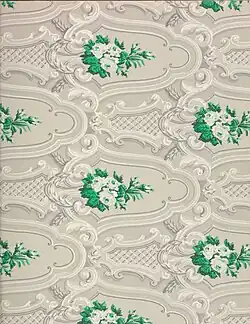 Detail of ornate wallpaper in a gray, white, and green design.