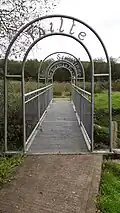 An iron pedestrian bridge with the gaelic term "Failte" above it