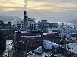 Photograph of the brick Speight's building with a tall chimney topped with a beer barrel