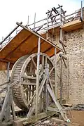 A treadwheel crane or 'squirrel cage' at Guédelon Castle.