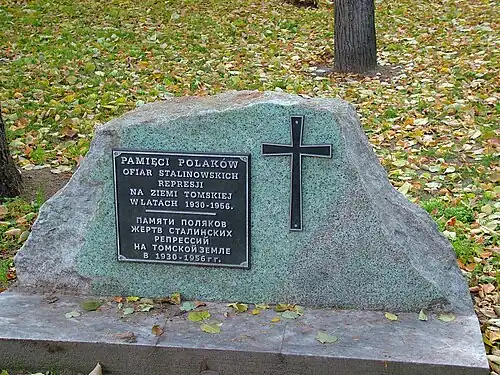 A memorial stone with a cross and plaque