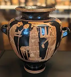 A bearded man, elaborately dressed, with two attendants: one bows and holds a thyrsus.