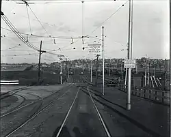 A junction between two streetcar lines, with a rail yard in the background