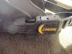 Swim fin strap attachment with swivelling plastic buckle and clip