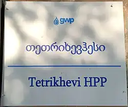 Information plaque on a white background. At the top is the 'gwp' company logo, below it is the text 'თეთრიხევჰესი' in Georgian, and at the bottom, 'Tetrikhevi HPP' in English.
