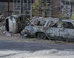 Film set of broken cars with growing foliage