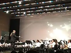 Conductor leads band students onstage