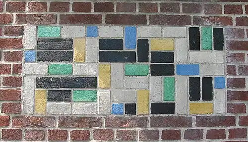 De Stijl&nbsp;– Panel of polychrome bricks on the exterior of the Vakantiehuis De Vonk&nbsp;[nl], a house in Noordwijkerhout, the Netherlands, by Theo van Doesburg, 1917–1919[72]