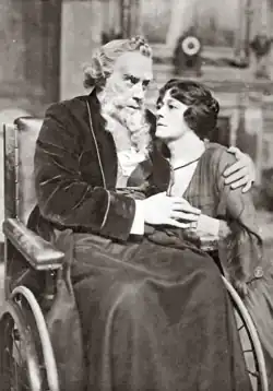 Old man in a bath-chair, with a youngish woman at his side