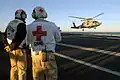 Senior medical officers and flight surgeons wear white with Red Cross emblems.