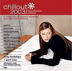 A woman wearing a black shirt is laying down on a white bed and glancing to the right of the camera; the album's title is displayed above her against a red background in a white font.