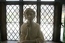 View of a white marble bust of Virginia Courtauld in an upper floor window of Eltham Palace