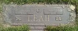 Flat bronze plaque with the family name Leah centred at the bottom, and the names of Vince and Mary above with their birth and death years