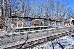 A metal high-level railway platform with a ramp down to track level
