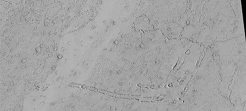 Rootless Cones, as seen by HiRISE under HiWish program. These group of rings or cones are believed to be caused by lava flowing over water ice or ground containing water ice. The ice quickly changes to steam which blows out a ring or cone. Here the kink in the chain may have been caused by the lava changing direction. Some of the forms do not have the shape of rings or cones because maybe the lava moved too quickly; thereby not allowing a complete cone shape to form.