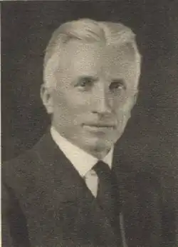 Article subject facing camera, wearing a suit coat and necktie