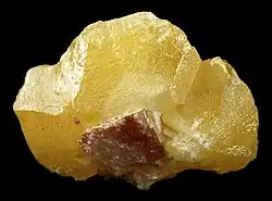 A yellow crystal elongated on its sides, with a small attached cerussite in front. Kunene Region, Namibia