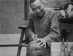 A man cutting a melon in half